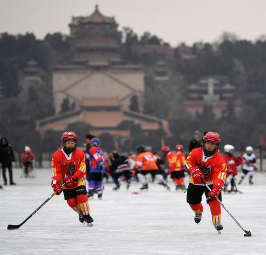 2018年1月21日，几名少年冰球队员在北京颐和园昆明湖冰面上练习冰球。新华社记者李俊东摄
