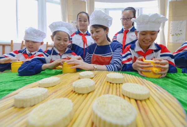 9月21日，河北省邯郸市邯山区南关小学学生在老师的指导下制作月饼。 新华社 图